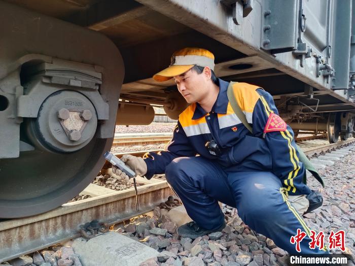 圖為張建亮在檢查車(chē)輛軸承溫度。 朱俊麟 攝 圖為張建亮在檢查車(chē)輛軸承溫度?!≈炜△?攝
