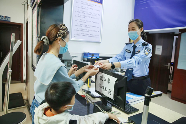 林女士領(lǐng)取兒子的第一張居民身份證。重慶市公安局治安管理總隊(duì)供圖