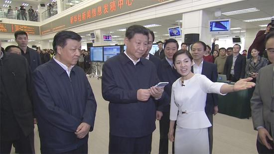 在新華社新聞信息發(fā)稿中心，習(xí)近平通過手機移動平臺為新聞工作者點贊。