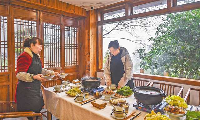 一月十五日，縉云村，“山之語”民宿老板周紅（右）正在為客人準備美食。