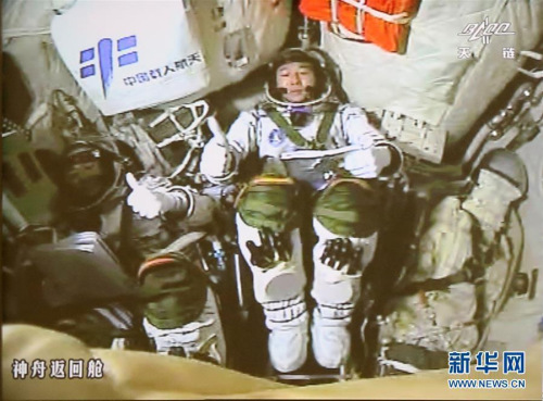 10月19日凌晨，神舟十一號飛船與天宮二號自動交會對接成功。這是兩名航天員景海鵬(右)和陳冬在完成對接后豎起大拇指相互祝賀(攝于北京航天飛行控制中心大屏幕)。新華社記者 琚振華 攝 圖片來源：新華網(wǎng)