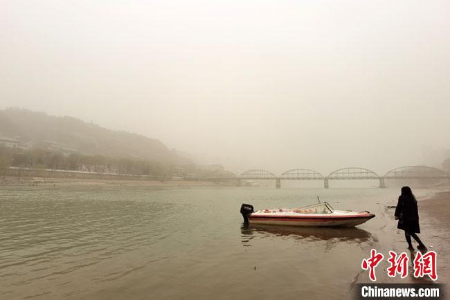 圖為3月16日傍晚，蘭州城區(qū)的黃河岸畔蒼白一片?！●T志軍 攝